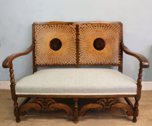 A CHARMING EARLY 20TH CENTURY TWOSEATER SOLID OAK FRAMED SOFA MODELLED IN THE LATE 17TH CENTURY STYLE